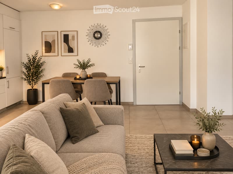 Modern living and dining area with a grey sofa, coffee table, dining table, chairs, decorative vases, picture frames, and a wall clock.