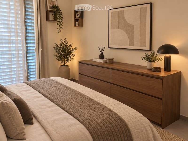 Modern bedroom with a wooden nightstand, a bed with a textured quilt and pillows, a floor lamp, and decorative items including a potted plant and a framed artwork on the wall.