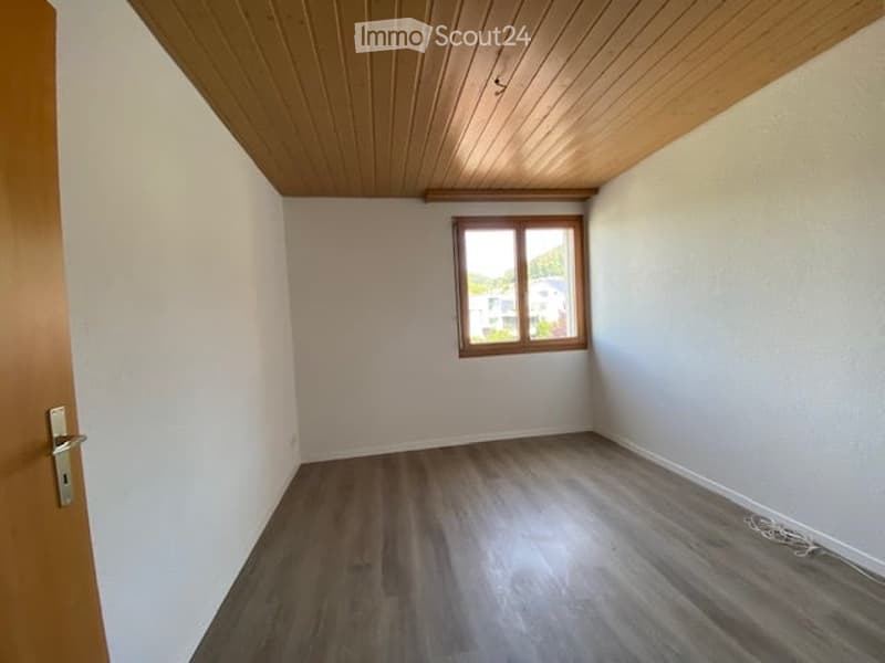 Empty room with wooden flooring, white walls, and a window with wooden frame. No furniture or equipment present.