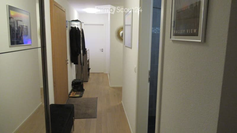 wooden floor, hallway, closet, picture frames, mirror, rug, bench
