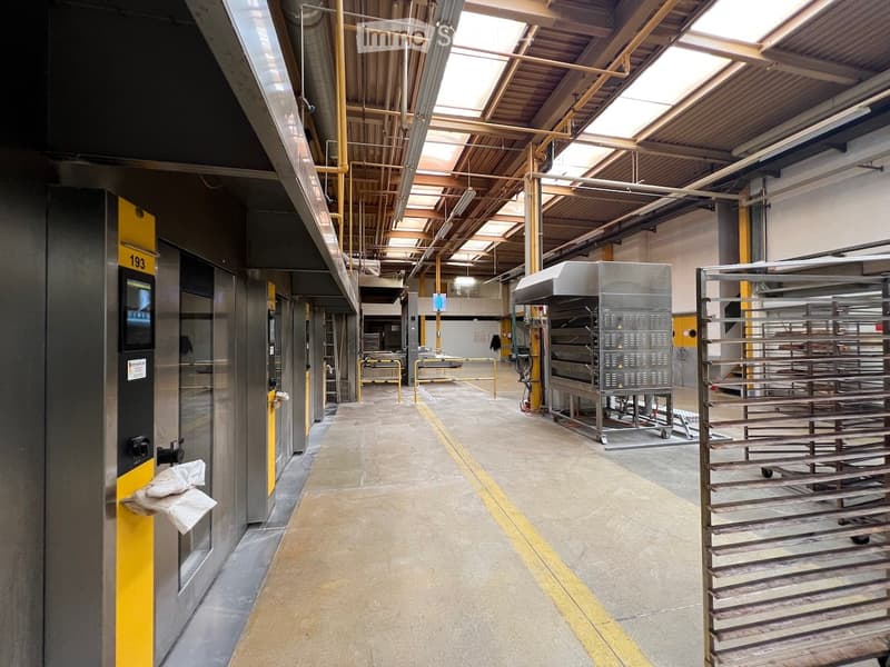 large industrial area, stainless steel machines, yellow barriers, gray floor, white walls, metal ceiling