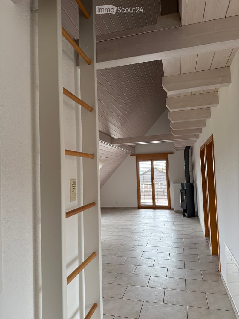 Modern hallway with wooden staircase, tiled floor, white walls, and a sliding glass door leading to an outdoor area.