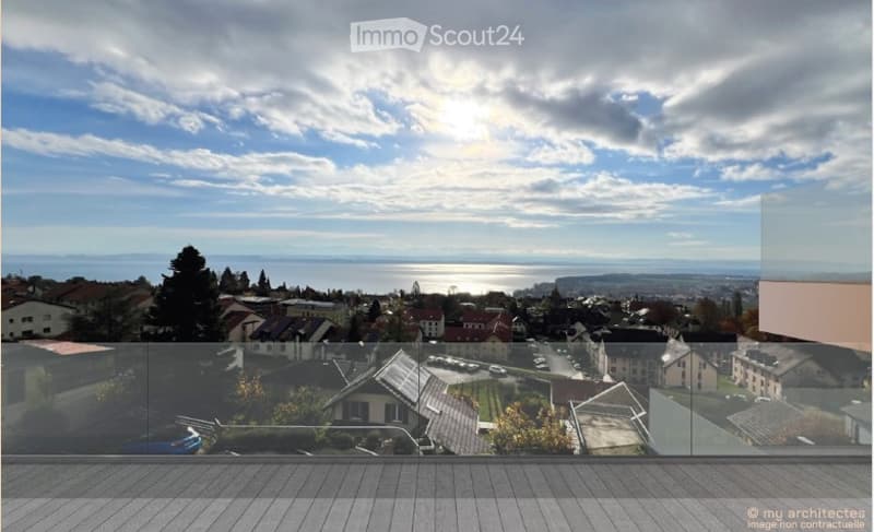 View from a glass balcony overlooking a cityscape and a seascape