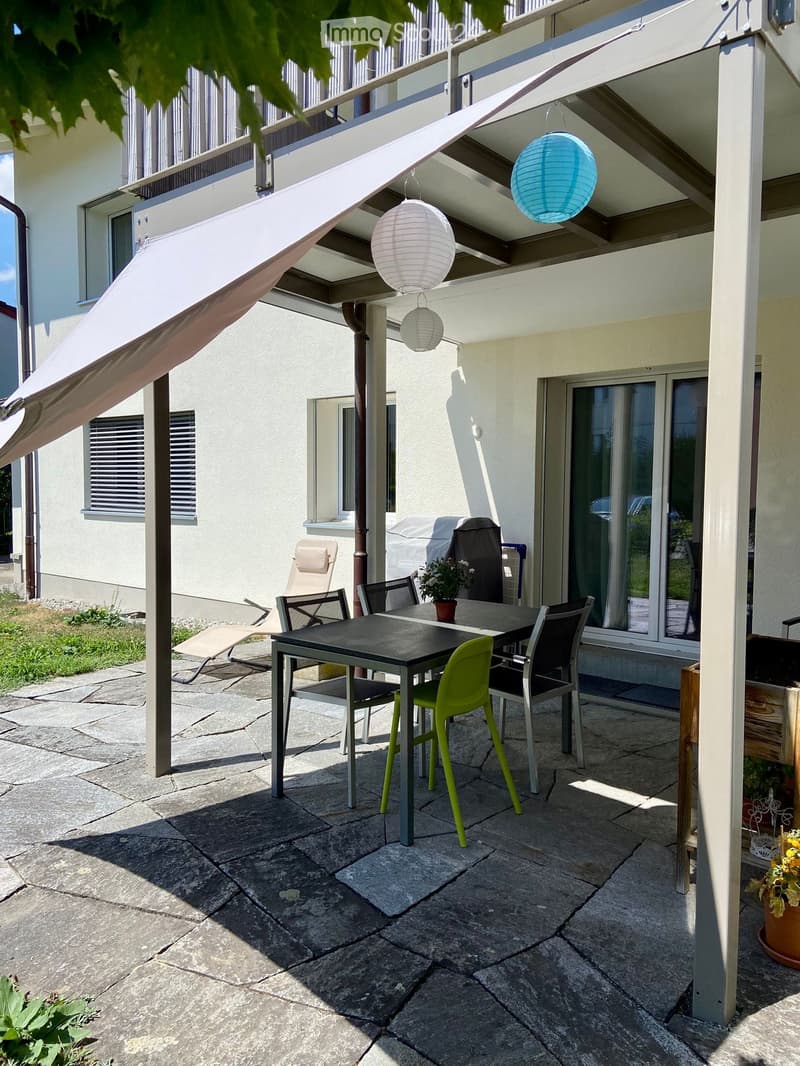Balcony with a dining table and chairs, a covered awning, and hanging lanterns.