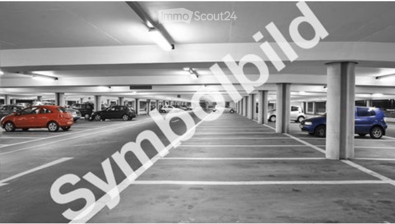 Underground parking lot with multiple parked cars, concrete pillars, and marked parking spaces.