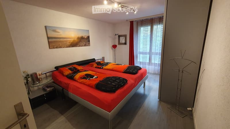 bedroom with two single beds, window with curtains, flower vase, side tables, closet