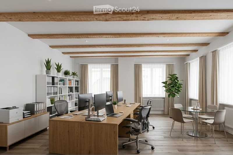 Modern office space with exposed wooden beams, large windows, office desk with multiple monitors, chairs, laptop, printer, bookshelf with books and plants, and a small round glass table with chairs.