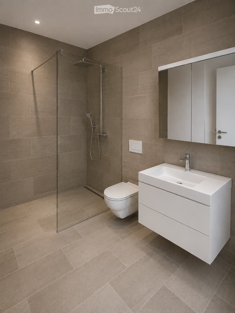 Modern bathroom with brown tiled walls and floor, white toilet, sink with modern faucet, mirrored cabinet, and glass-enclosed shower area.