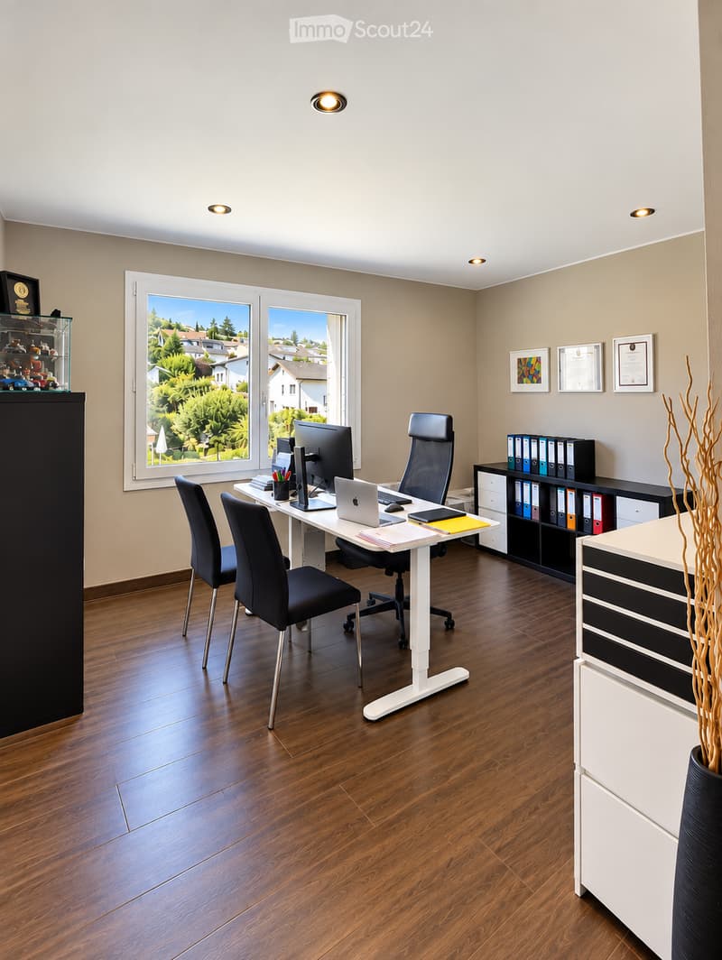 Modern office space with wooden flooring, large window offering a view, desk with laptop, monitor, keyboard, mouse, and chairs, filing cabinet, and decorative vase.