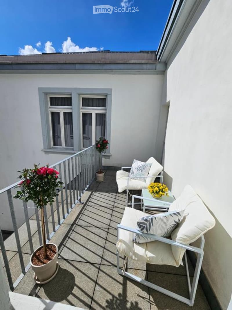 Small balcony, seating area, railing, potted plants, flowers, view of sky