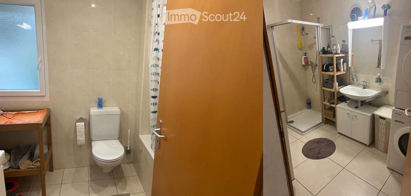 Bathroom with a toilet, sink, mirror, shower, cabinet, shelf, washing machine, towel, bathrobe, cat litter box, and cat. The shower has a glass enclosure and a curtain. There is a small wooden shelf with various items, and a window letting in natural ligh