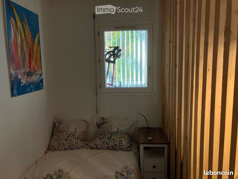 {"visible_features": [], "type": "Room", "description": "A small room featuring a bed, decorative pillows, a nightstand, and a painting on the wall; there is a window overlooking the outside, partially covered by blinds, with sunlight illuminating the spa