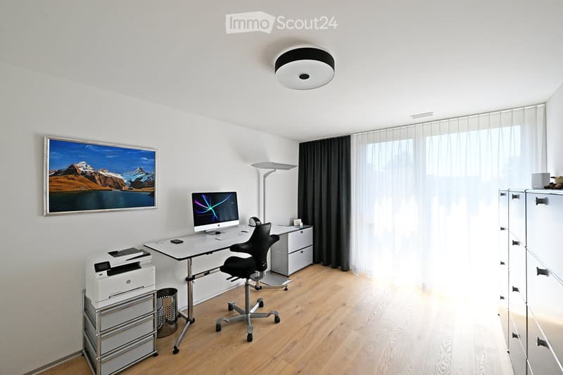 White walls, wooden floor, white desk, chair, printer, large painting, white curtains, round ceiling lamp