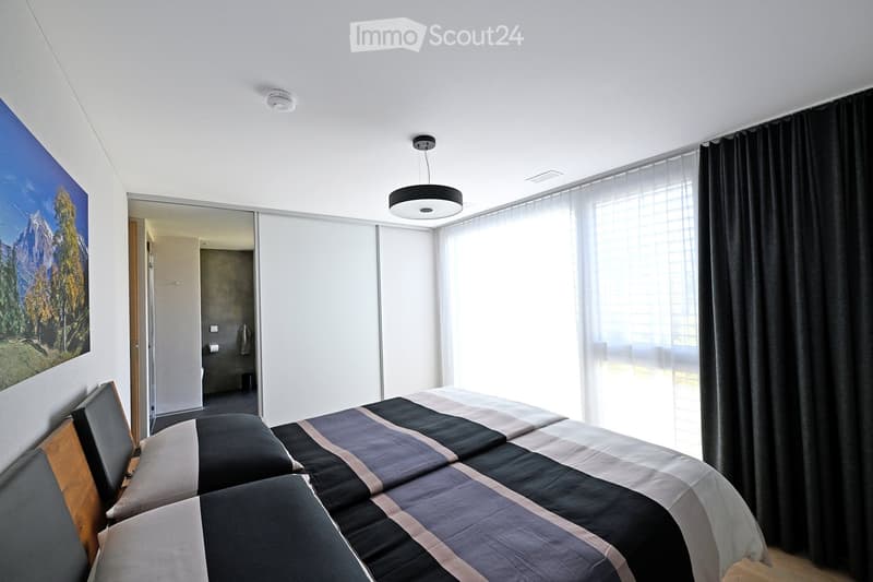 room with two double beds, bed linens, night lamp, wall with painting, white curtains