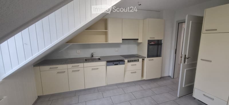 Modern kitchen with white cabinets, granite countertops, stainless steel sink, and built-in appliances including an oven and dishwasher.