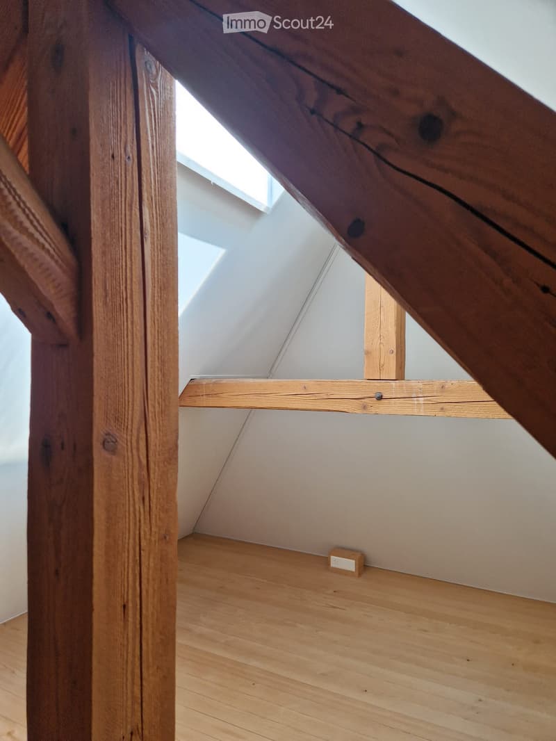 wooden floor, wooden beams, slanted ceiling, natural light