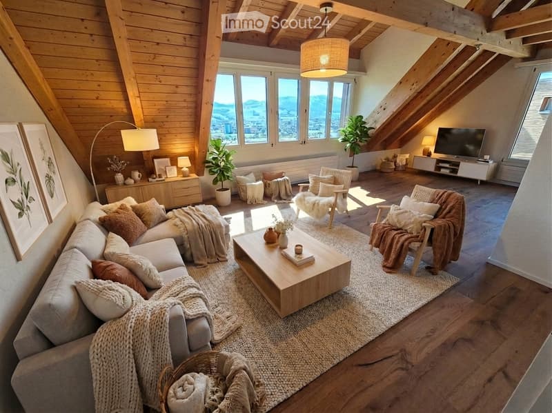 Modern living room with exposed wooden beams, large windows offering a scenic view, a grey sectional sofa, wooden coffee table, armchairs, floor lamp, sideboard, and potted plants.