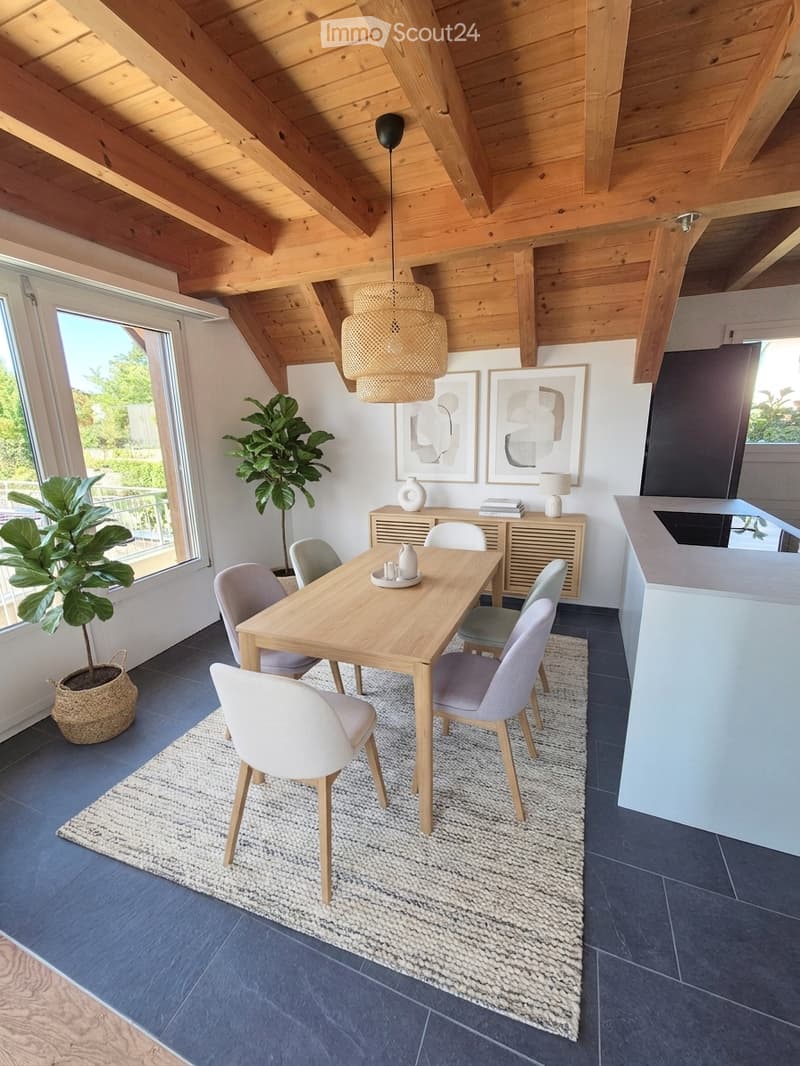 Modern dining area with a wooden dining table, six chairs, a sideboard, pendant light, and large windows offering a view of greenery.