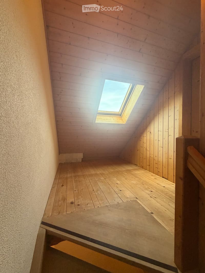 Wooden staircase leading up to a skylight, with wooden walls and floor, and a wooden handrail on the right side.