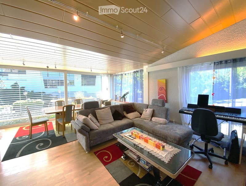 Empty room with wooden flooring, large windows, and recessed lighting. No furniture or equipment present.