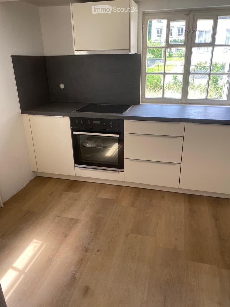 modern kitchen with white cupboards, granite countertops, oven and hob, tiled floor, windows