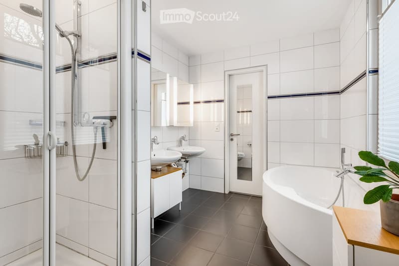 modern bathroom, white tiles, shower enclosure, 2 sinks, round bathtub, wooden cabinet, mirror