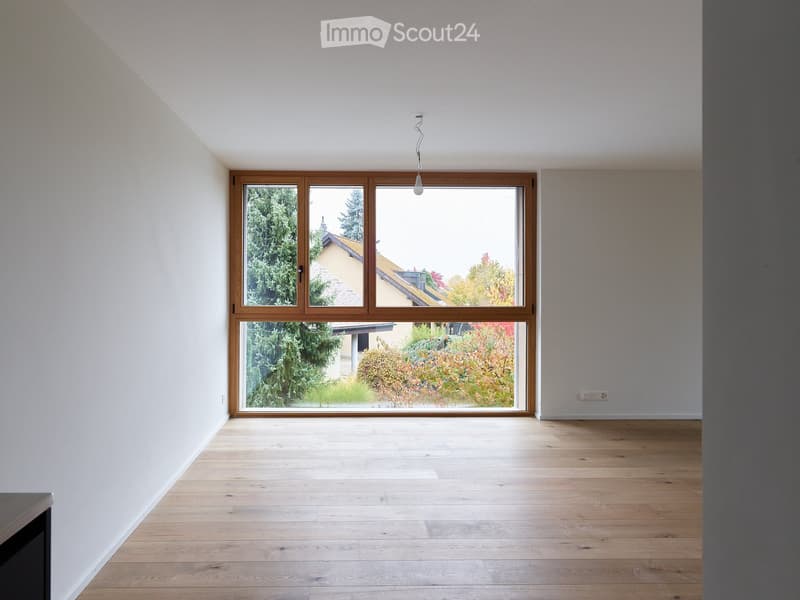 empty room with wooden floor, large window, white walls