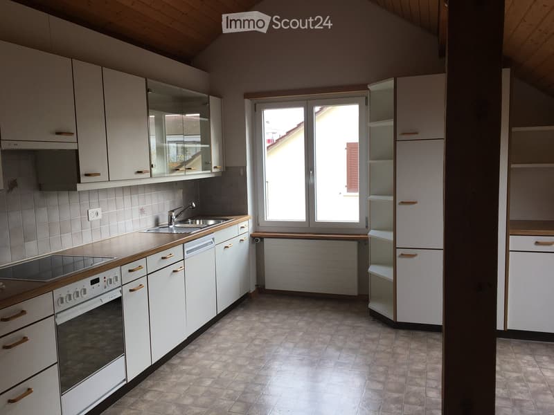 Bright kitchen with white cabinets, wooden countertops, and tiled floor. Features a sink, faucet, oven, and dishwasher.