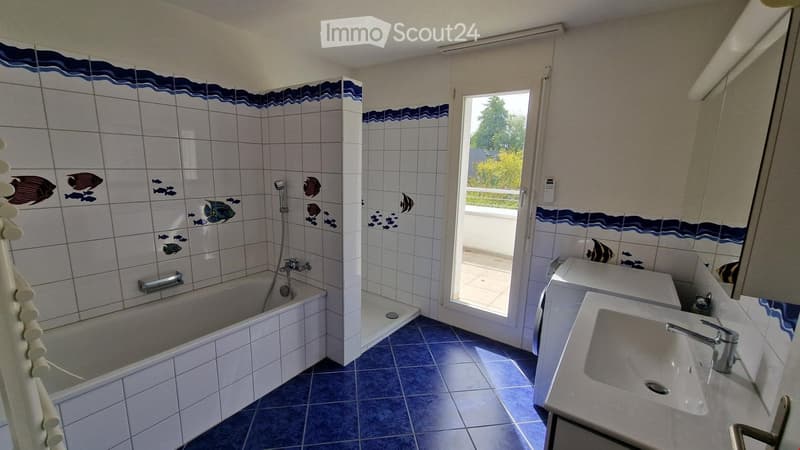white and blue tiled walls, white and blue tiled floor, bathtub, shower, sink, white washing machine