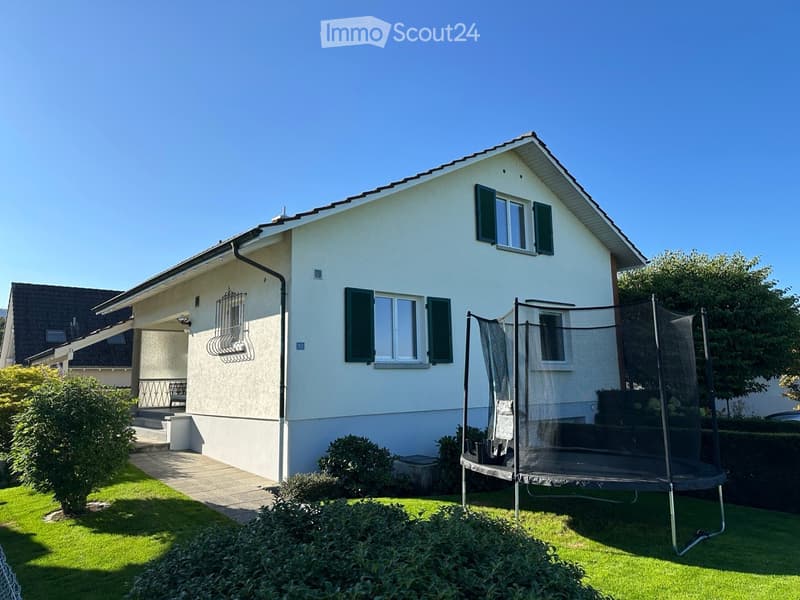 2-story house, white exterior, green shutters, covered front porch, green lawn, trampoline