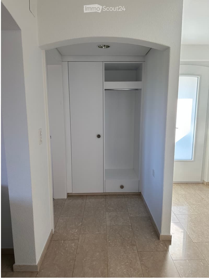 White wall, White door, built-in wardrobe with drawer, tiled floor, power outlet, hallway.