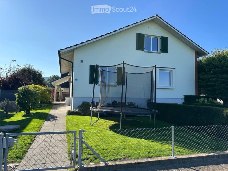 Single family house, white exterior, black shutters, fenced yard, trampoline, pathway, green grass