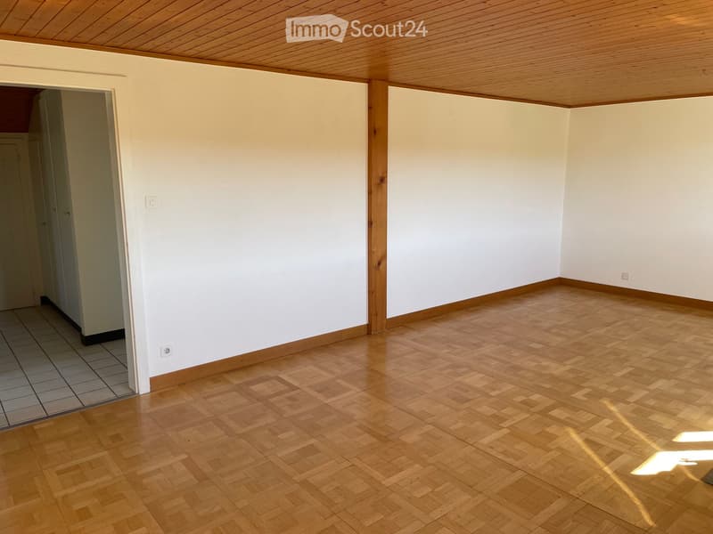 Empty room with light-colored walls, wooden floor, and a wooden ceiling. No furniture or equipment is present.