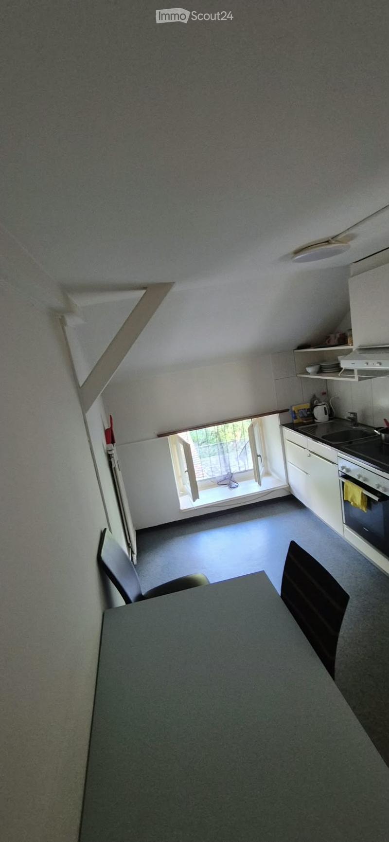 Compact kitchen with a dining area, featuring a table, chairs, oven, fridge, sink, and cupboards.