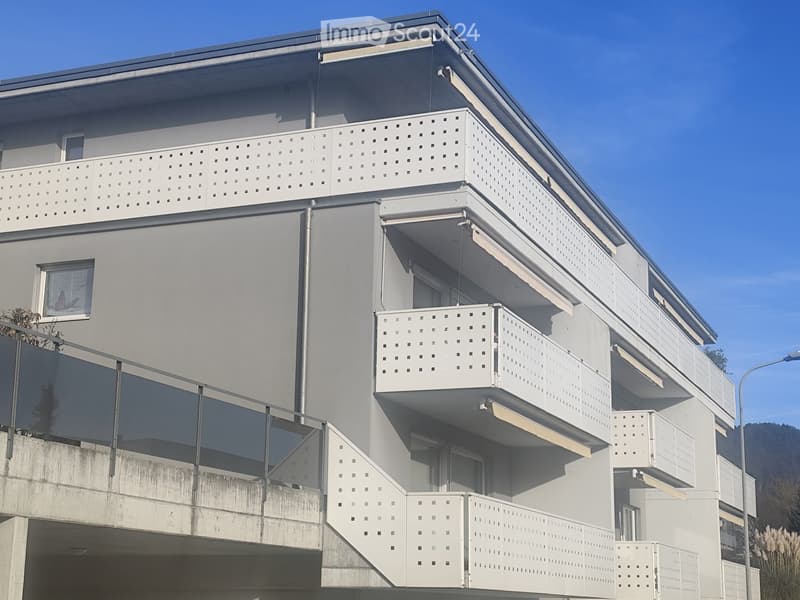 3 storey building, grey walls, balconies, modern style