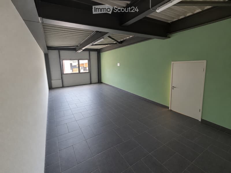 Empty room with dark tiled floor, green wall, white door, and window with blinds.