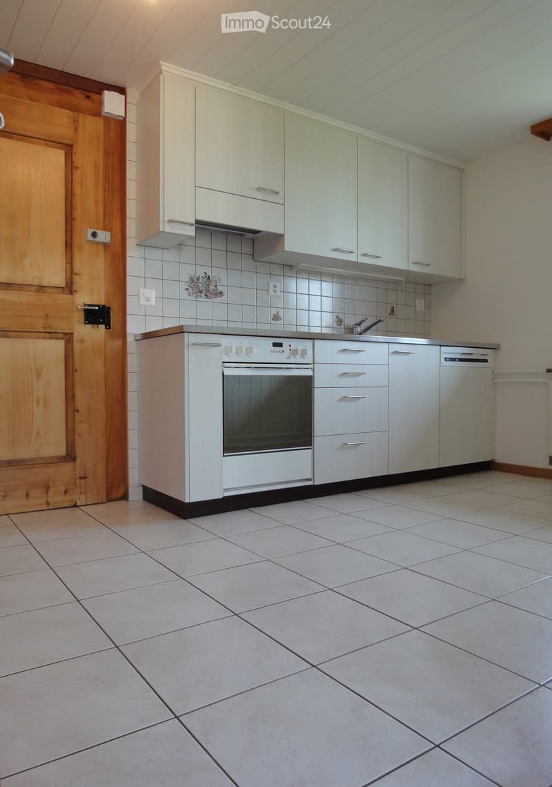 Modern kitchen with white cabinets, an oven, a dishwasher, and tiled walls and floor.