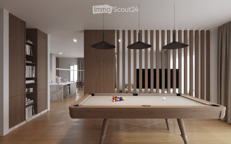Modern, open-concept room with a pool table, bookshelf, and a kitchen area in the background.