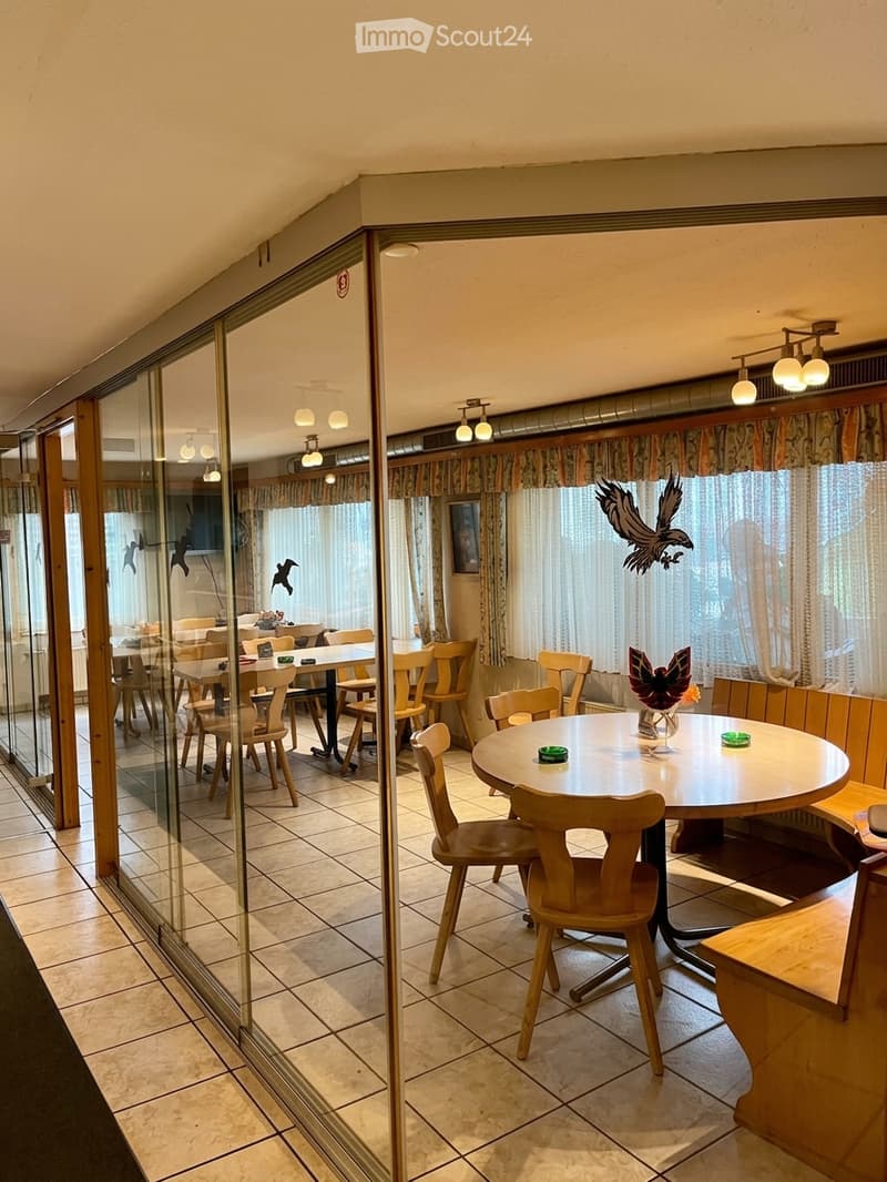 Dining area with round wooden table, chairs, bench seating, and decorative items.