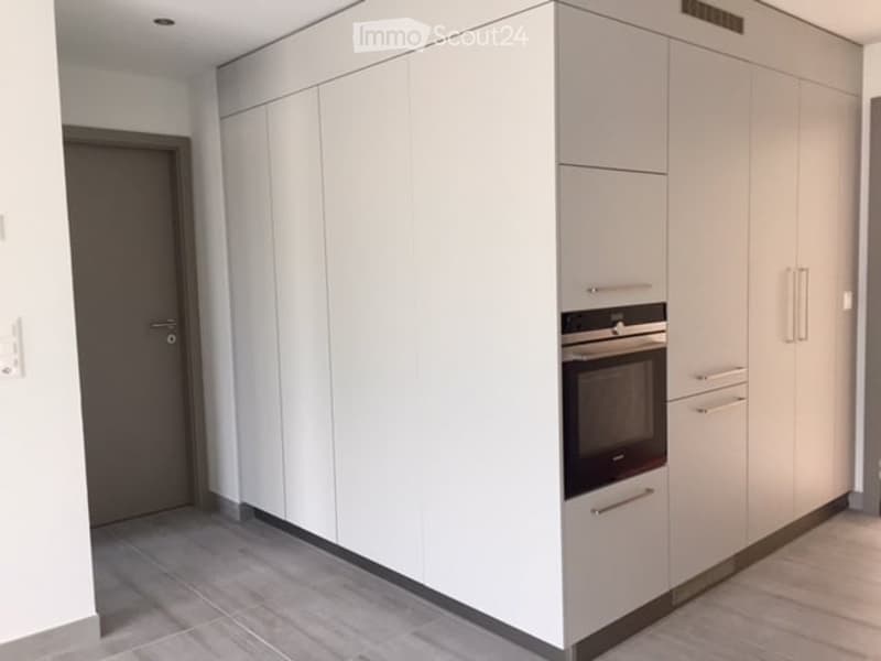 Modern kitchen with white cabinets and a built-in oven, featuring sleek design and contemporary finishes.