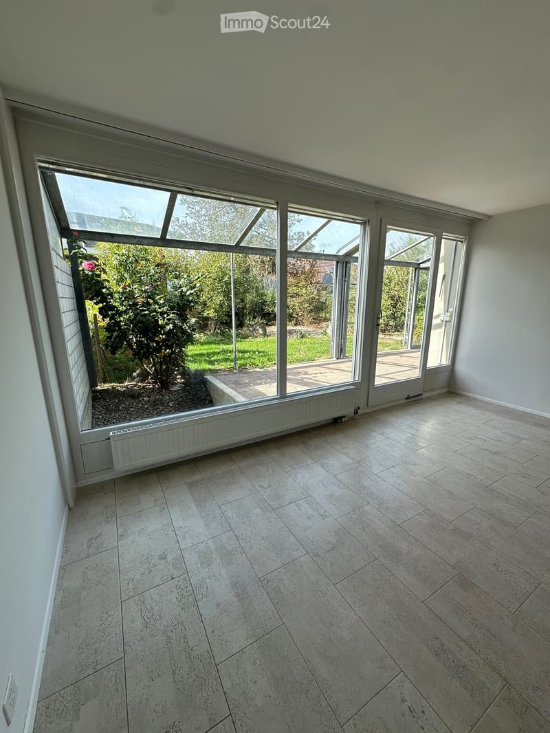Blick aus dem Wohnbereich in den Wintergarten und Ökologisch angelegten Aussenbereich