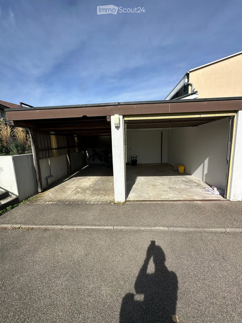 Garage mit elektrischem Rolltor und gedeckter Autounterstellplatz