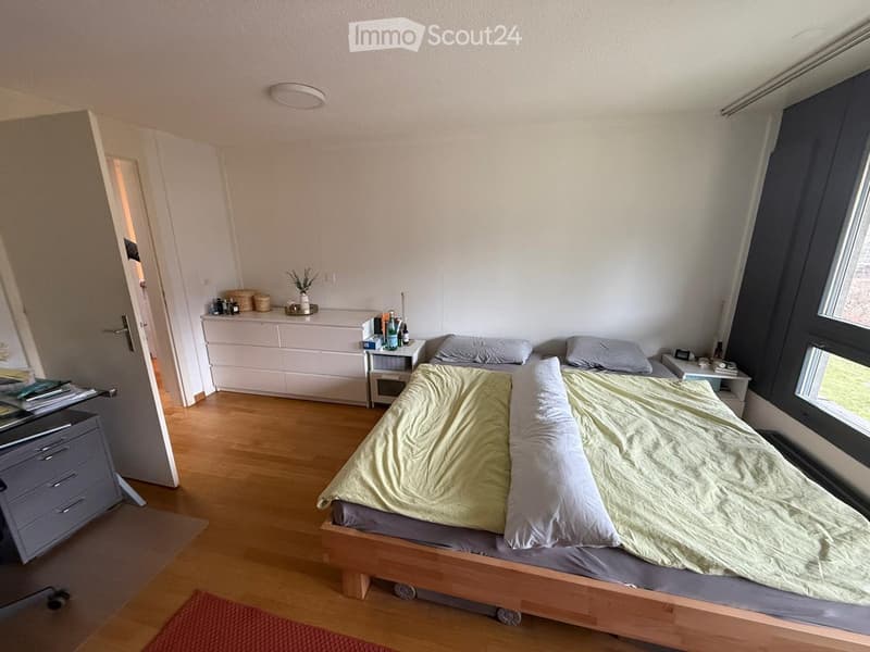 Cozy bedroom with a wooden bed, nightstands, and a small table with decorative items.