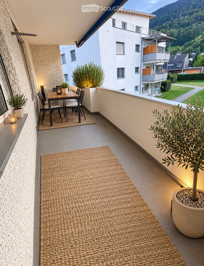Balcony with a small dining area, potted plants, and scenic mountain view.