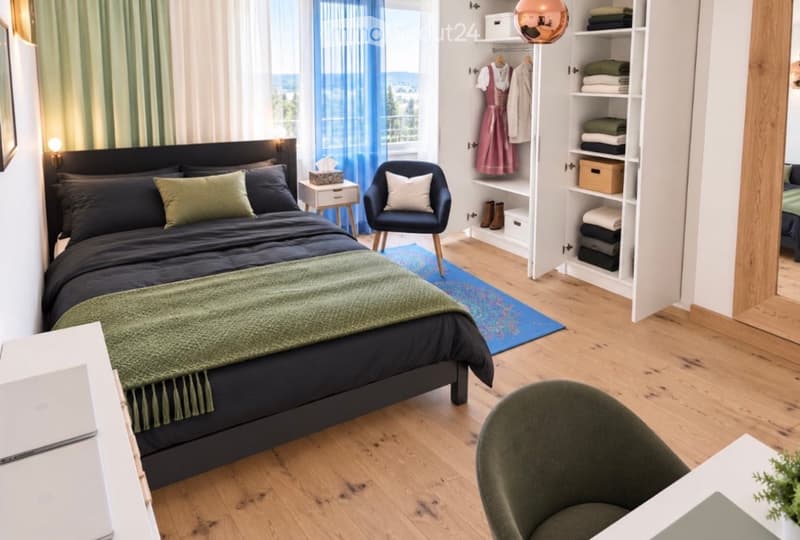 Modern bedroom with a large bed, nightstand, wardrobe, and a small seating area with a chair and table.