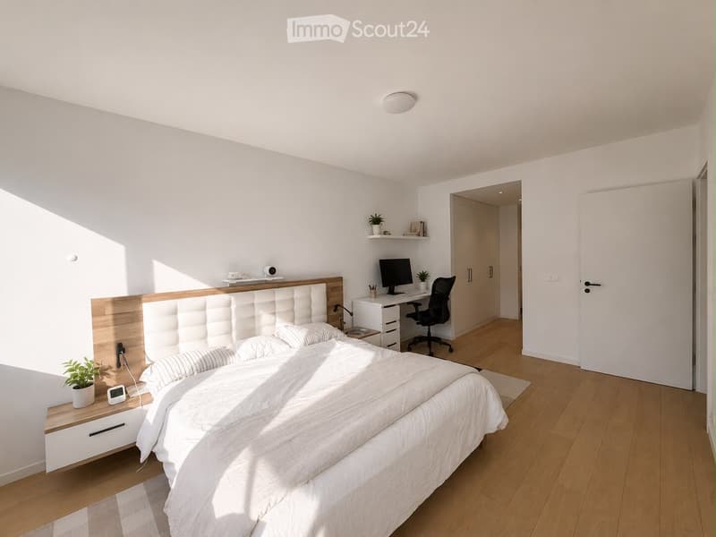 Modern bedroom with a large bed, white bedding, wooden nightstand, desk with a laptop, chair, and small plants on shelves.