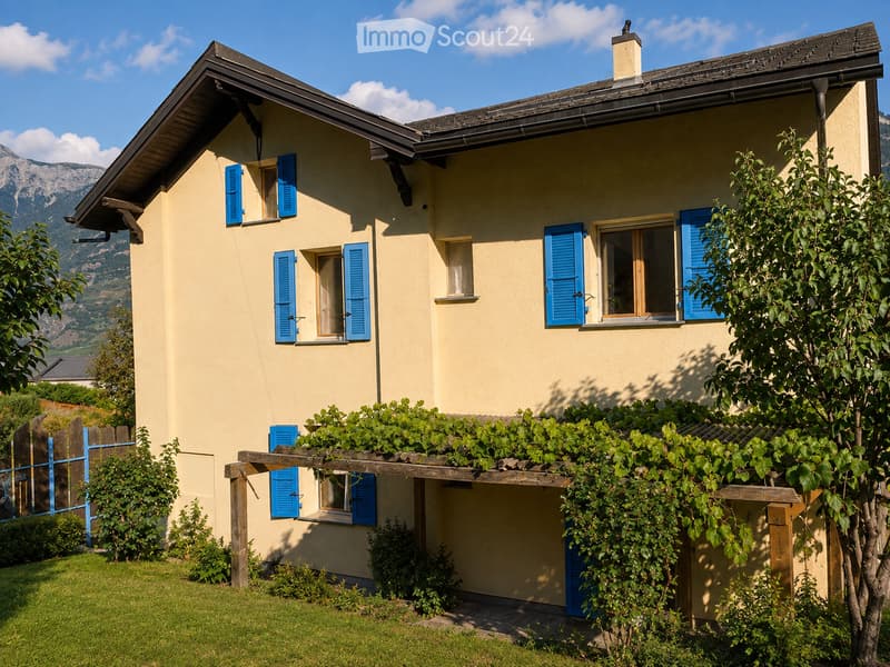 Two-story house with light yellow walls, blue shutters, and a wooden pergola covered with vines. The house features multiple windows and is surrounded by a well-maintained garden with green grass and shrubs.