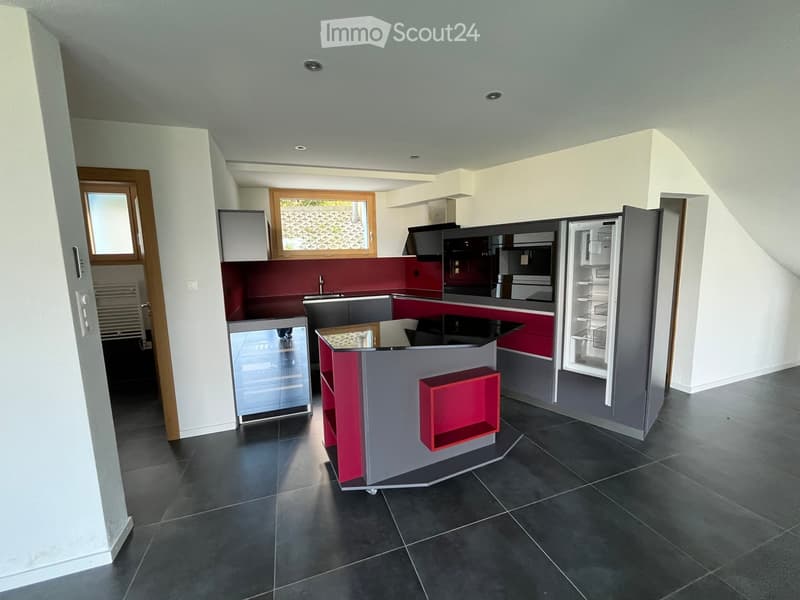 modern kitchen with island, red countertops, modern appliances, wooden floor, sliding door