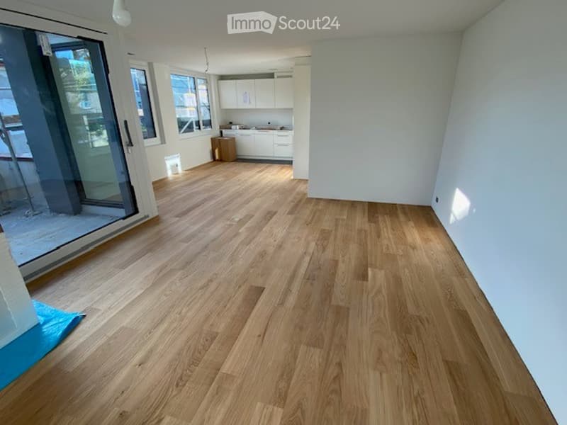 Completely empty room with light wooden flooring and white walls. No furniture or equipment.