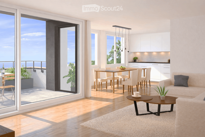 Bright, modern living and dining area with large windows and a balcony. Features a cream sofa, coffee table, dining table with chairs, and a small potted plant on the coffee table.